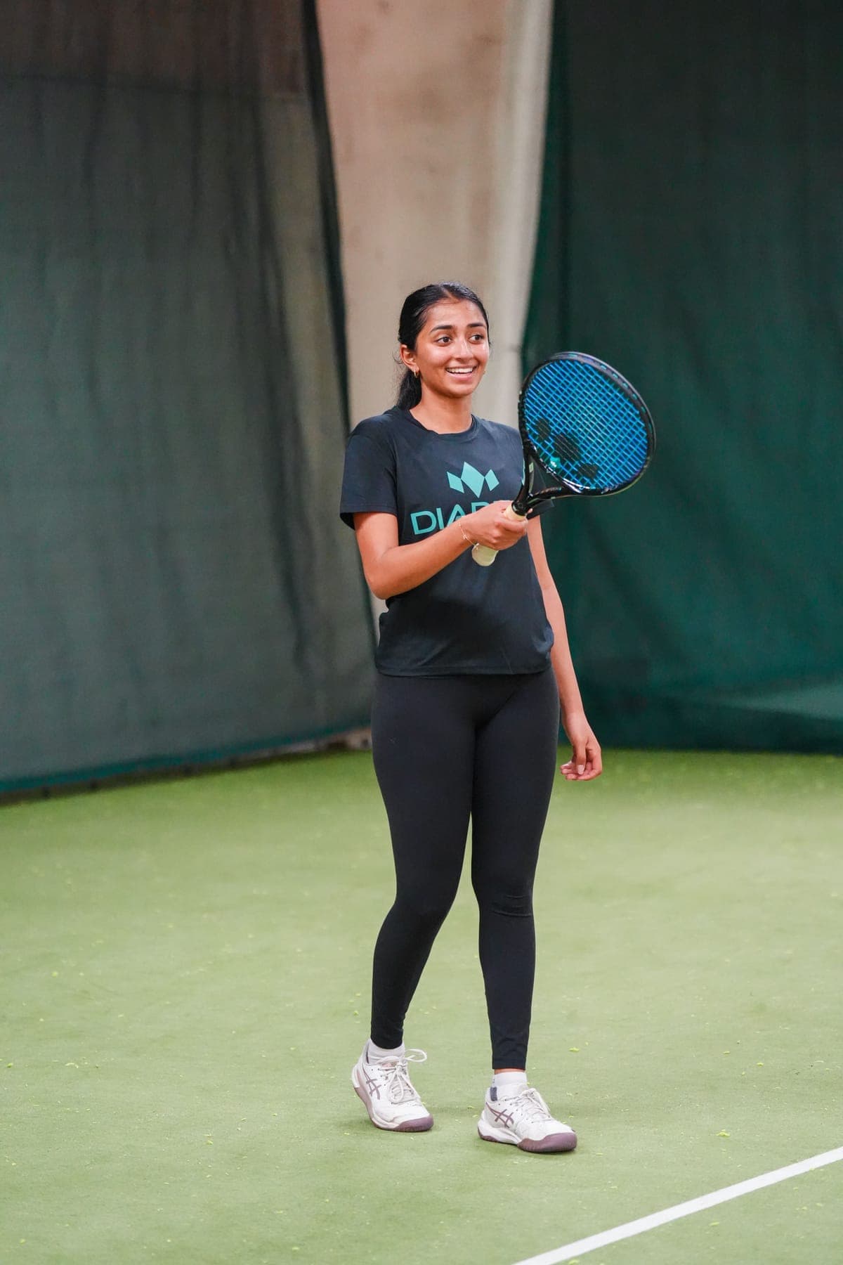 A Diadem hitting partner smiling on court