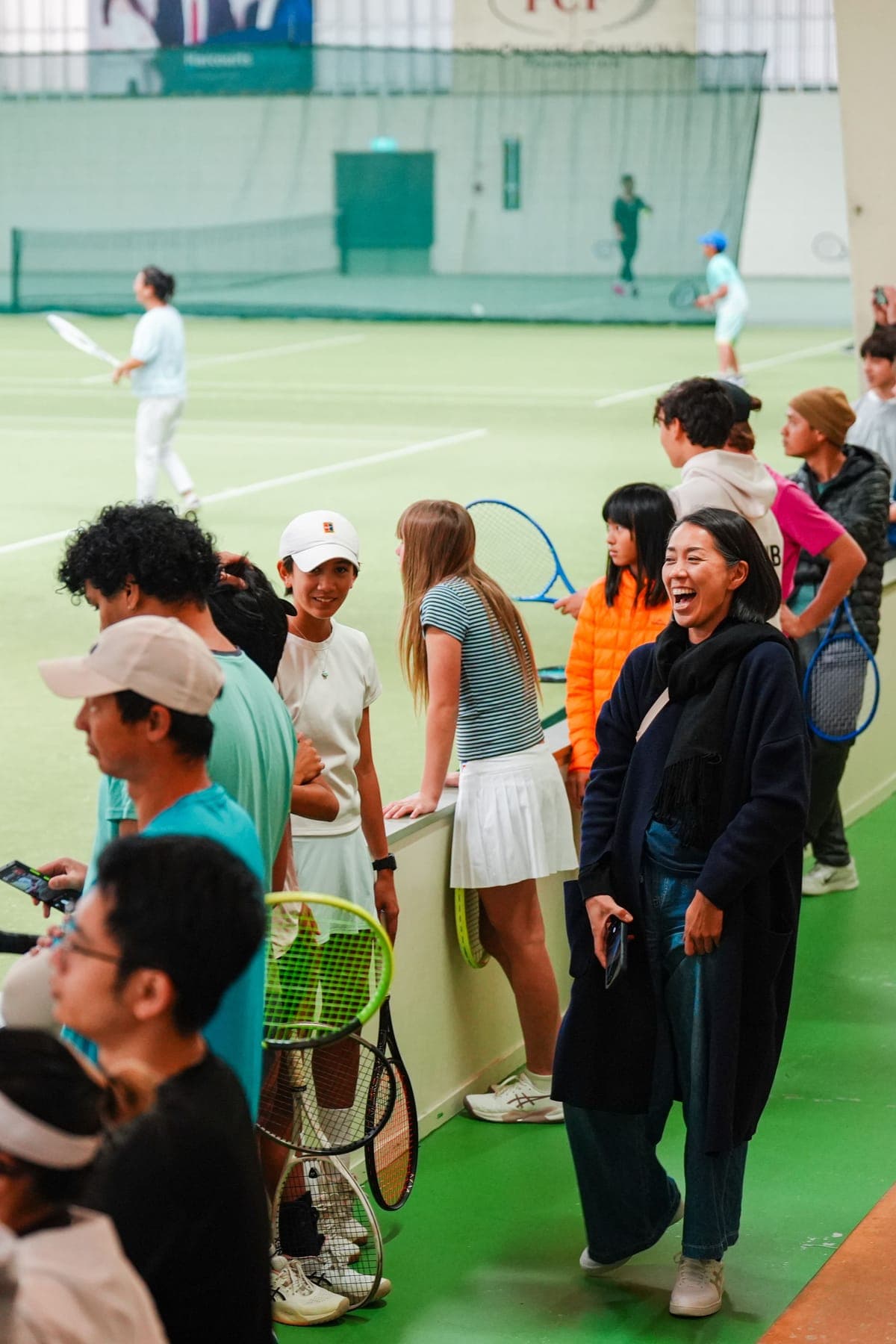 Players with rackets queuing beside the challenge court