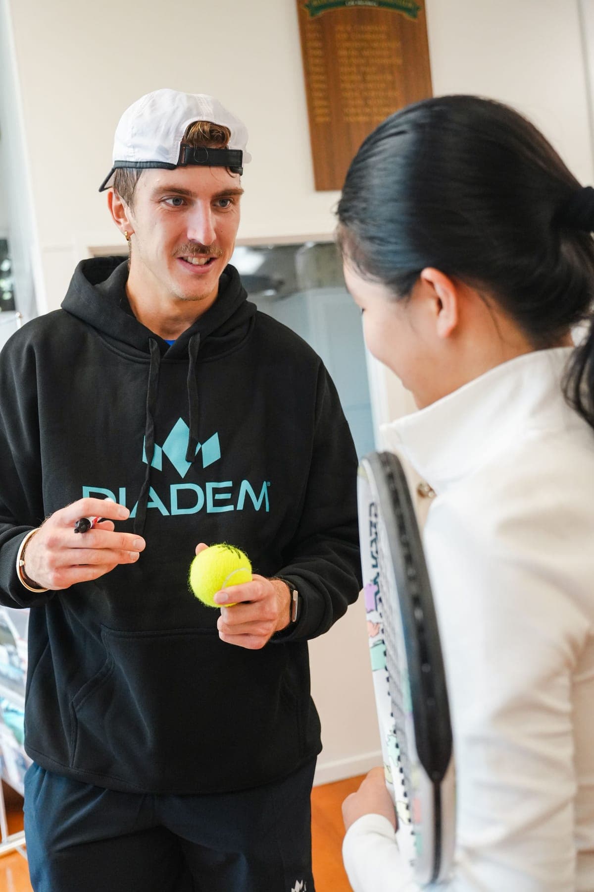 Anton with a pen, about to sign a ball